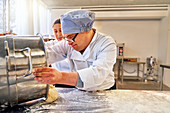 Young male student with Down Syndrome baking in kitchen