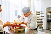 Focused young male student with Down Syndrome baking bread