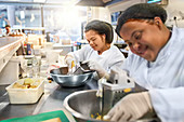 Women with Down Syndrome grating cheese in cafe kitchen