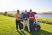 Portrait mature male friends golfing on sunny golf course