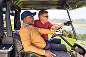 Mature men in golf cart