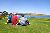 Male golfers relaxing looking at lake view