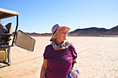 Senior woman on safari in sunny arid desert South Africa