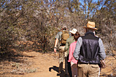 Guide leading group in sunny grassland South Africa