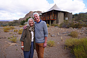 Portrait happy senior couple outside safari cabin