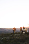 Group drinking tea on hill at sunrise South Africa