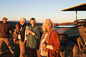 Senior woman on safari drinking champagne with friends