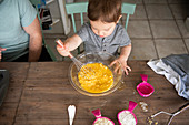 Curious toddler girl baking