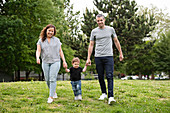 Portrait happy young family walking grass