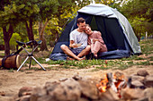 Happy couple relaxing in tent at campsite