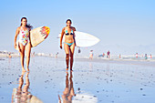 Portrait young female surfers on sunny ocean beach