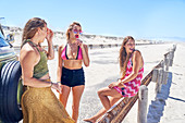 Young women friends relaxing at sunny summer beach