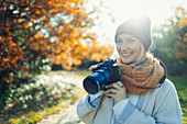Woman with digital camera in autumn park