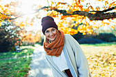 Woman in stocking cap and scarf in autumn park