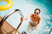 Woman at swimming pool ladder