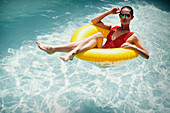 Woman relaxing, floating in inflatable ring