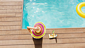 Woman in sun hat relaxing at poolside