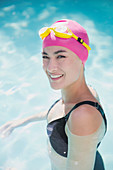 Woman in swimming cap and goggles in swimming pool