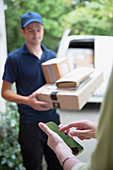 Woman signing smart phone for deliveryman at front door