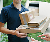 Woman signing digital tablet for deliveryman