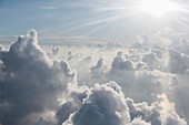 Aerial view sunbeams over fluffy clouds in sky