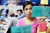 Businesswoman with adhesive notes planning in office