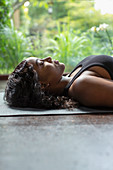 Serene woman laying on yoga mat