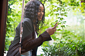 Woman using smart phone on patio swing