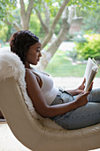 Woman relaxing reading book in living room