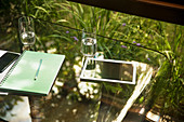 Digital tablet and water glasses on glass table