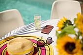 Sun hat and sunglasses on summer poolside table