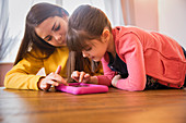 Teenage girl and young sister using tablet