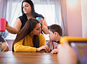 Boy with Down Syndrome talking to sister at dining table
