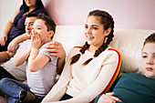 Happy family watching TV on living room sofa