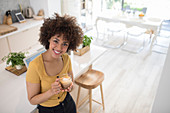 Woman drinking cappuccino in kitchen