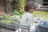 Portrait smiling woman using smart phone on patio