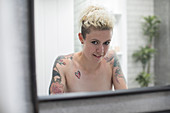 Portrait nude woman with tattooed shoulders
