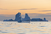 Majestic iceberg formations over sunset