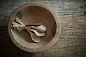 Wooden bowl and spoons on rustic surface