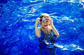 Portrait happy boy swimming in blue swimming book