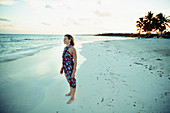 Woman in sun dress on tranquil ocean beach Mexico
