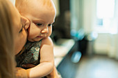 Close up mother kissing cute baby daughter