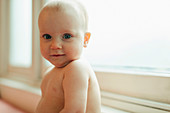 Portrait cute baby girl in window