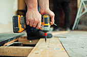 Close up construction worker installing floorboard