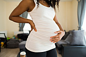 Young pregnant woman holding stomach