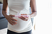 Close up pregnant woman with pill box taking vitamins