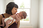 Affectionate mother holding newborn baby son