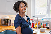 Portrait happy pregnant woman in kitchen