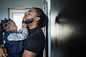Curious toddler son pulling father beard