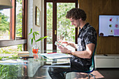Young man with digital tablet working in home office